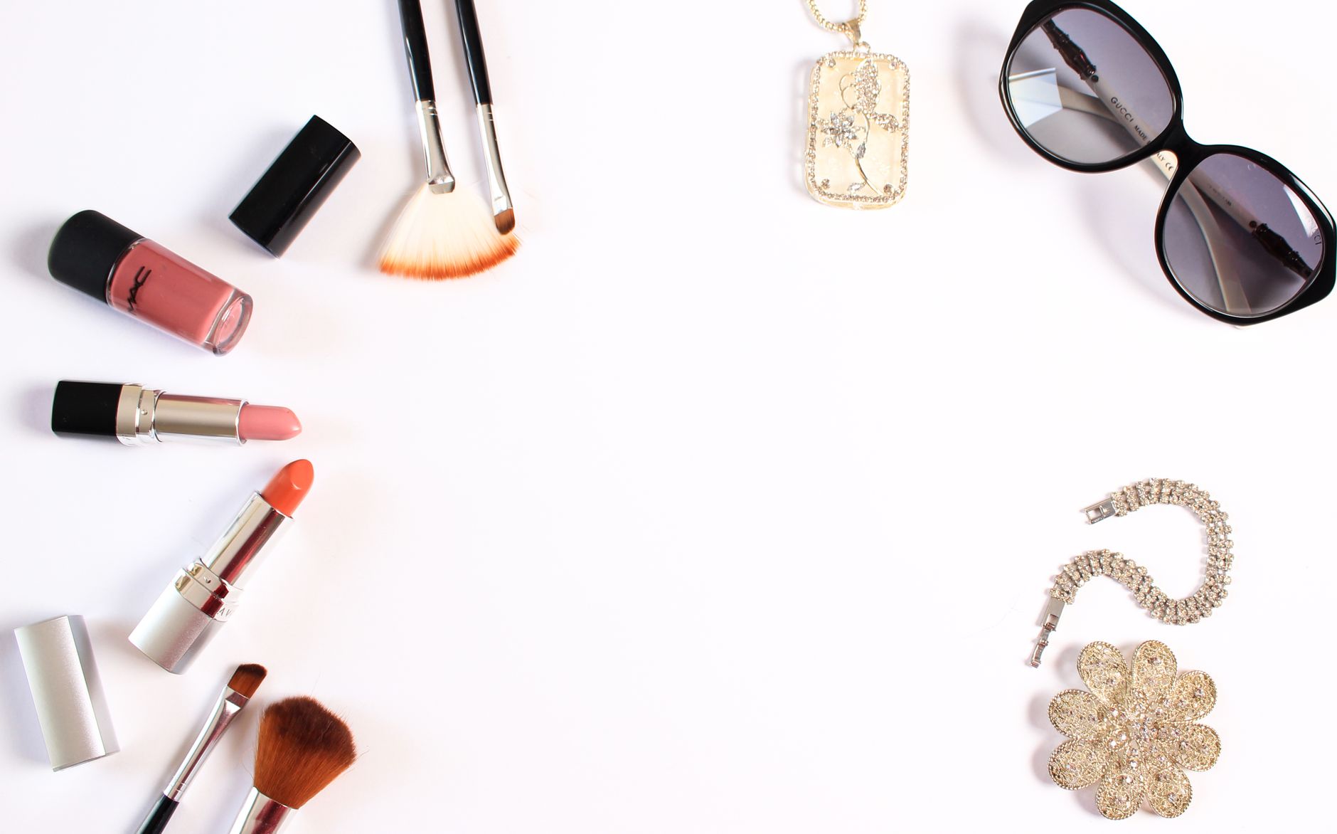Stylish flat lay of makeup brushes, lipsticks, and glam accessories on a white background. — examplearticle